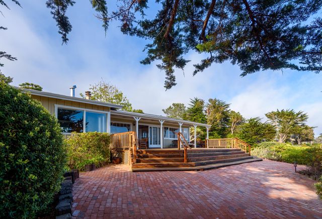 a view of house with backyard and a garden