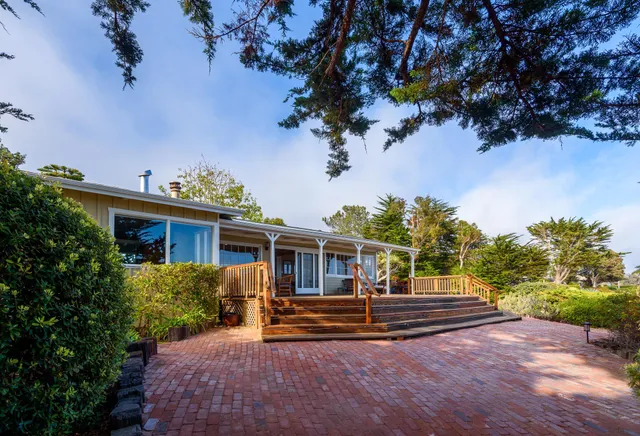 a view of house with backyard and a garden