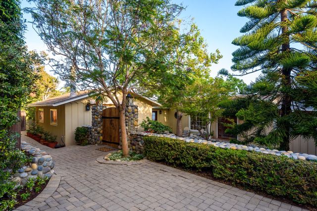 a view of a house with a yard and potted plants