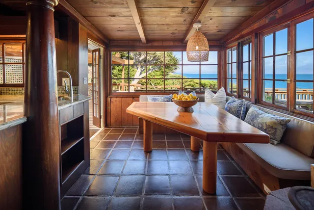 a dining room with furniture and a floor to ceiling window