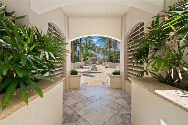 a living room with furniture potted plant and a large window