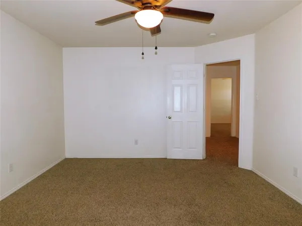an empty room with a chandelier fan