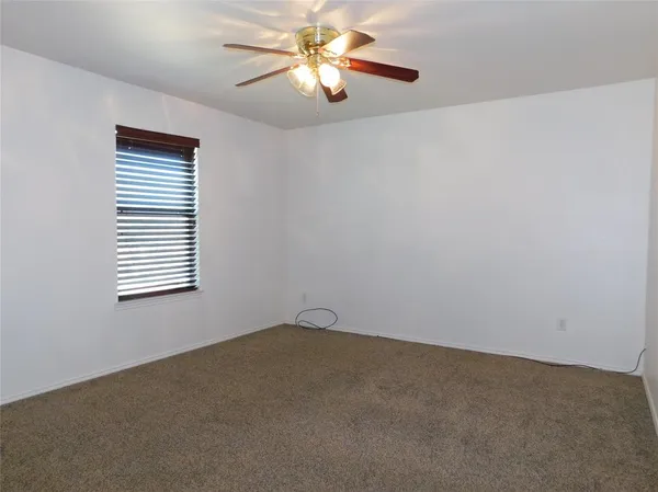 a view of a room with a ceiling fan and a window
