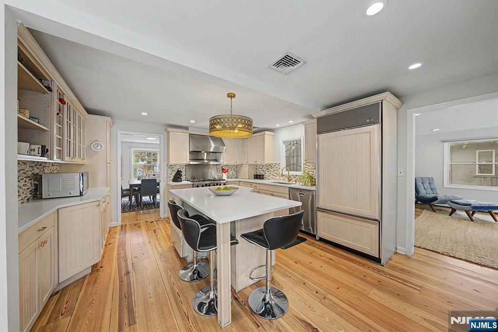 45 Highfield Road Bloomfield, NJ 07003 - Photo 20 of 50 a kitchen with stainless steel appliances a stove a refrigerator a sink dishwasher and a dining table with wooden floor