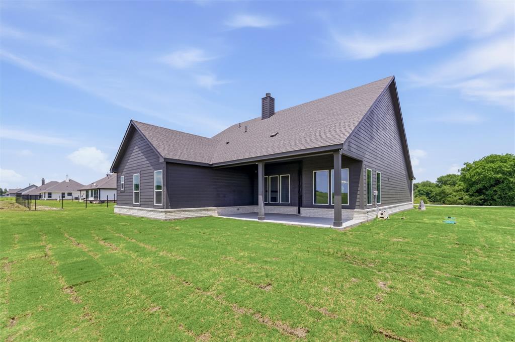 8861 County Road 623 Blue Ridge, TX 75424 - Photo 22 of 25 Modern home exterior featuring dark siding, a covered patio, multiple large windows, and a shingled roof