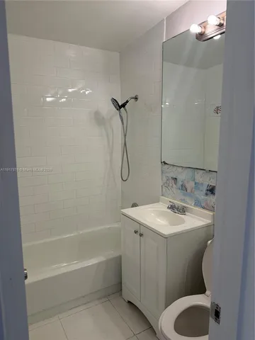 a bathroom with a granite countertop sink a toilet and shower