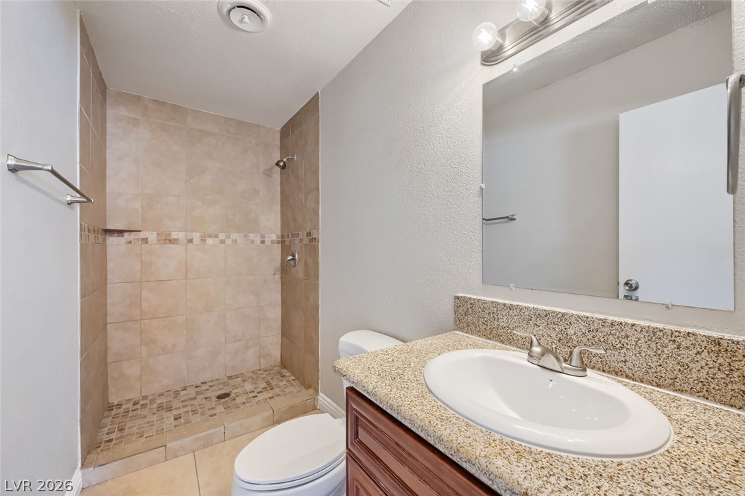 6321 Portola Road Las Vegas, NV 89108 - Photo 22 of 29 A well-appointed bathroom with a spacious tiled shower and functional vanity area.