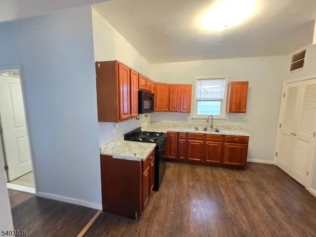 a kitchen with wooden floors and wooden cabinets