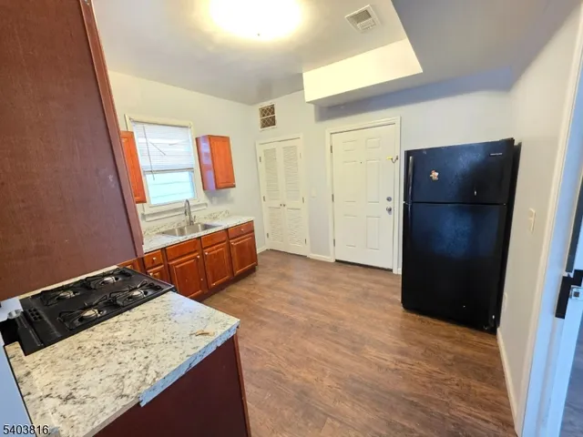 a kitchen with stainless steel appliances granite countertop a refrigerator and a stove top oven