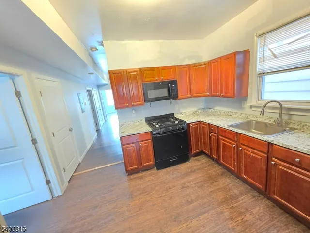 a kitchen with stainless steel appliances granite countertop a sink stove and wooden cabinets