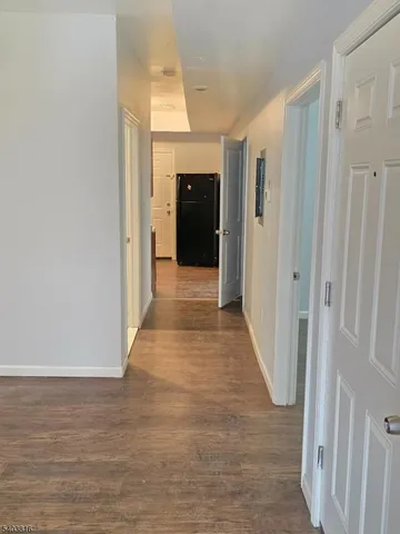 a view of a hallway with wooden floor and closet