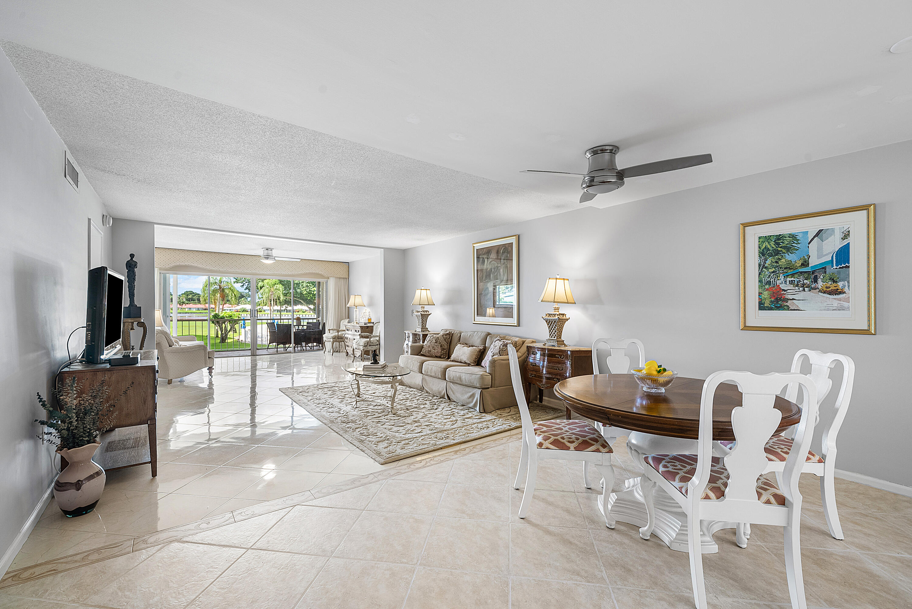 145 Atlantis Boulevard, Unit 201 Atlantis, FL 33462 - Photo 12 of 40 a living room with furniture large window and flat screen tv
