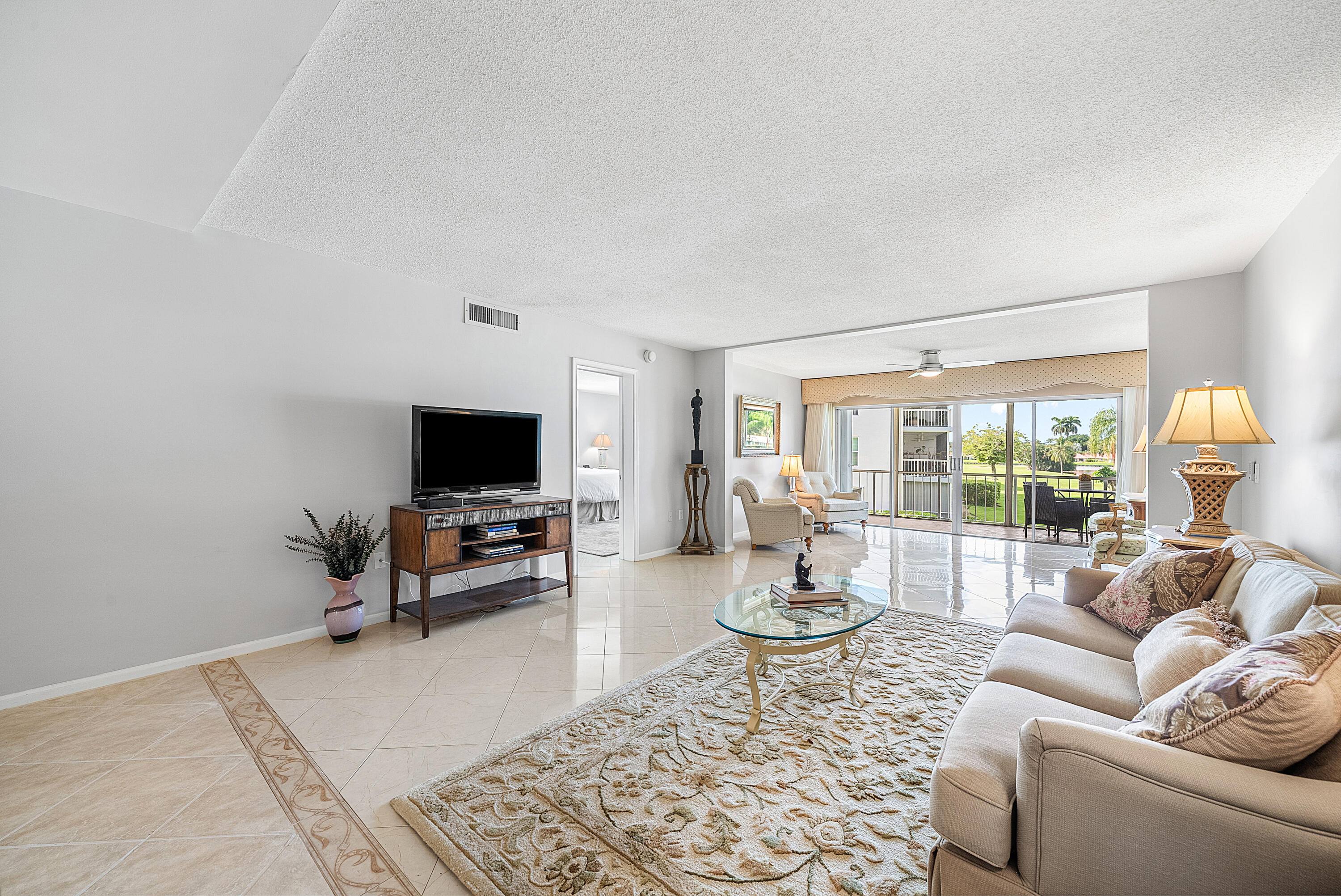 145 Atlantis Boulevard, Unit 201 Atlantis, FL 33462 - Photo 13 of 40 a living room with furniture and a flat screen tv
