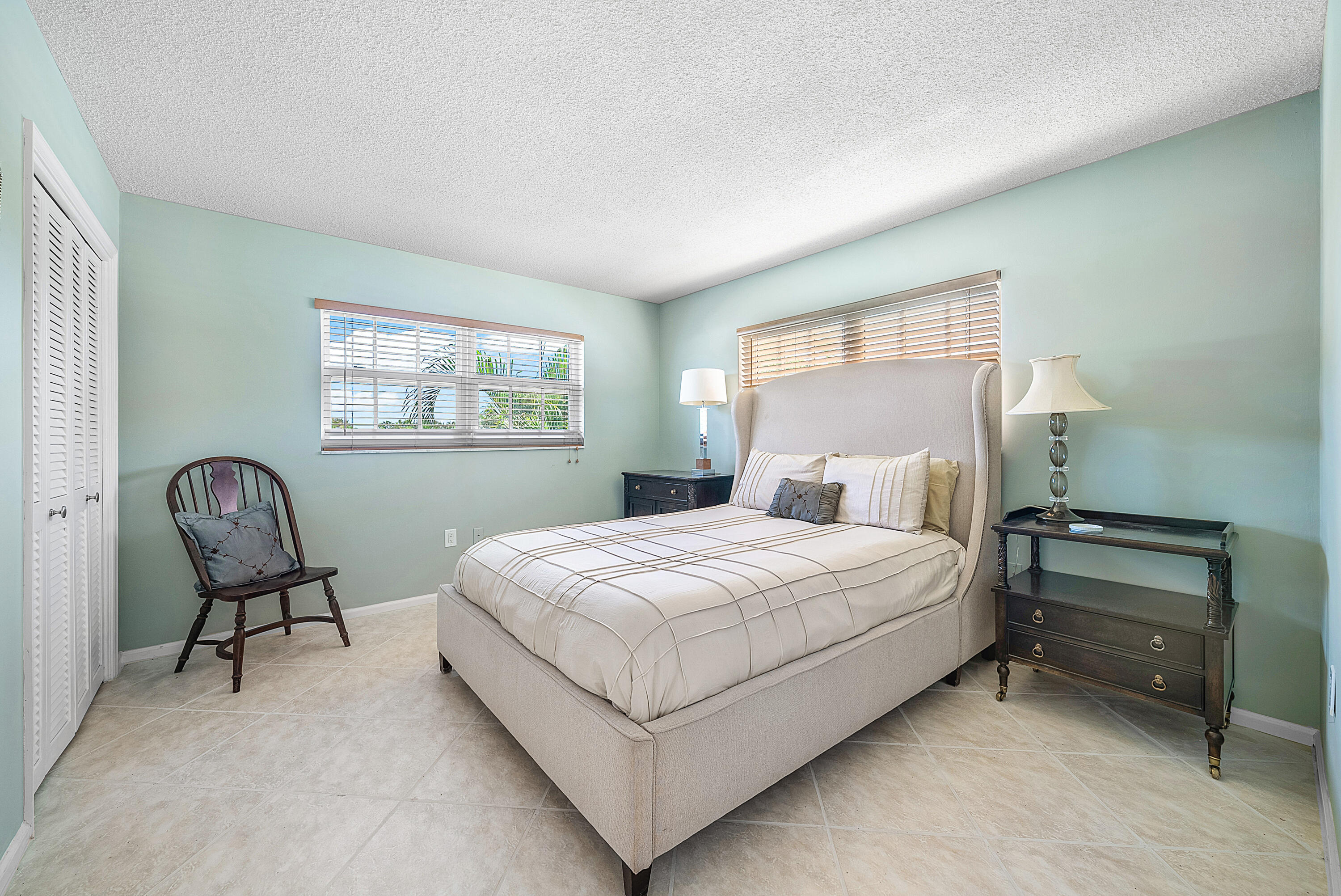 145 Atlantis Boulevard, Unit 201 Atlantis, FL 33462 - Photo 15 of 40 a bedroom with a bed wooden floor and window