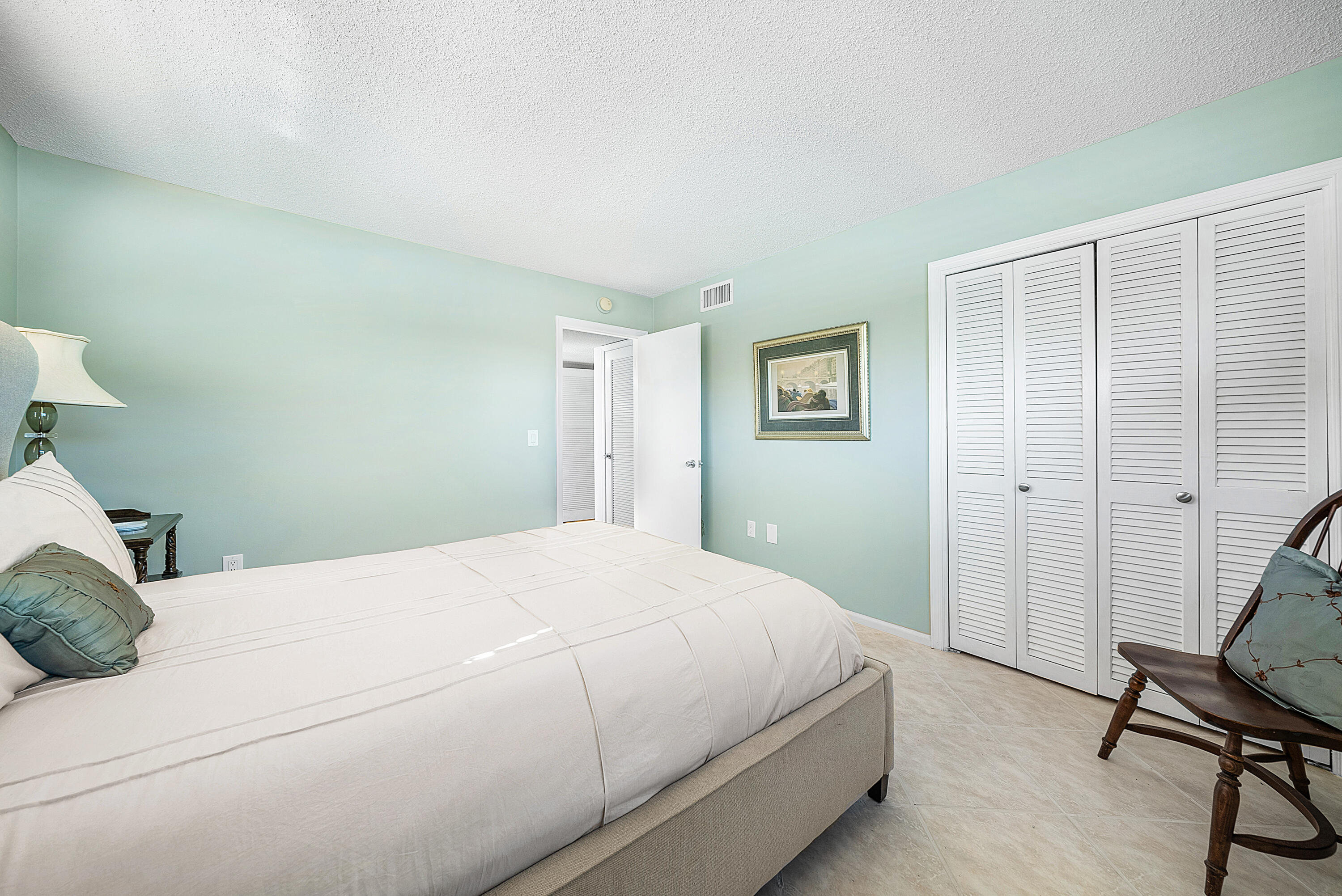 145 Atlantis Boulevard, Unit 201 Atlantis, FL 33462 - Photo 16 of 40 a bedroom with a bed and a window