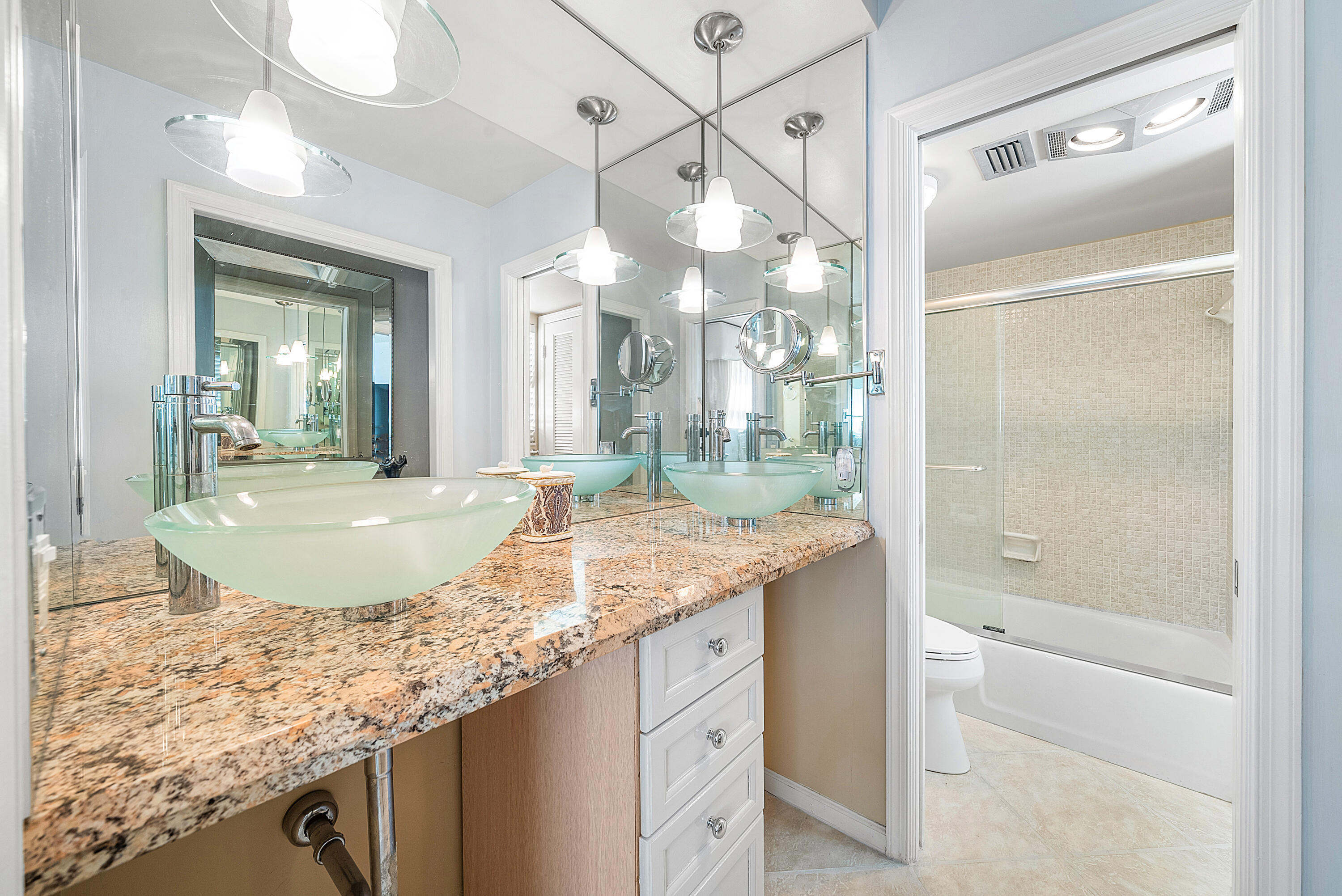 145 Atlantis Boulevard, Unit 201 Atlantis, FL 33462 - Photo 22 of 40 a bathroom with a granite countertop sink a mirror and a shower