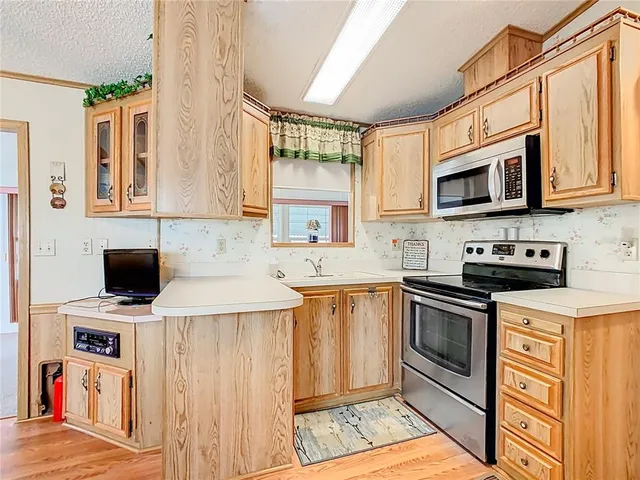 a kitchen with stainless steel appliances a stove sink microwave and cabinets