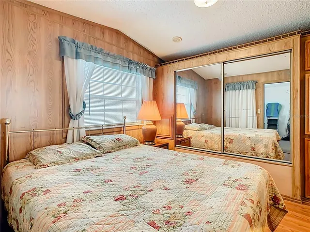 a bedroom with a large bed and a large mirror