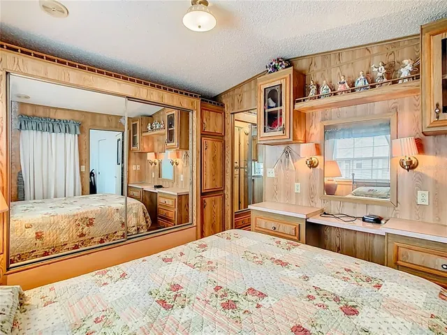 a bedroom with a bed and a large mirror on the dresser