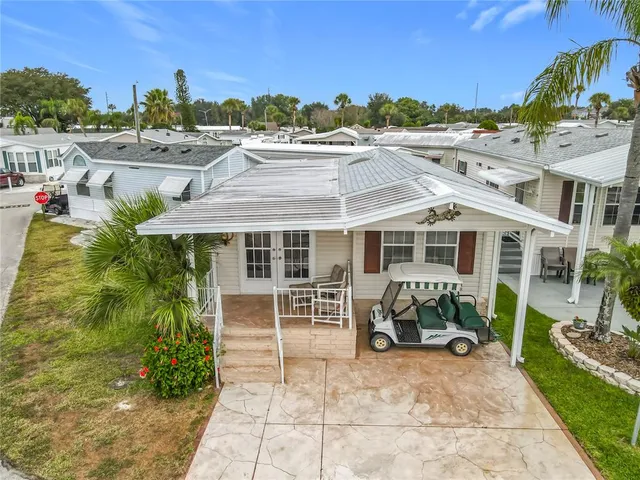 a view of a house with backyard sitting area and barbeque oven