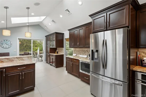 a kitchen with stainless steel appliances granite countertop a refrigerator a stove a sink and a refrigerator