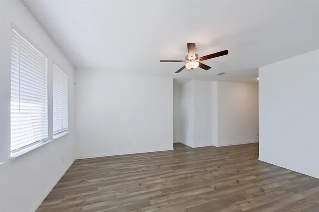 a view of a livingroom with wooden floor and a ceiling fan