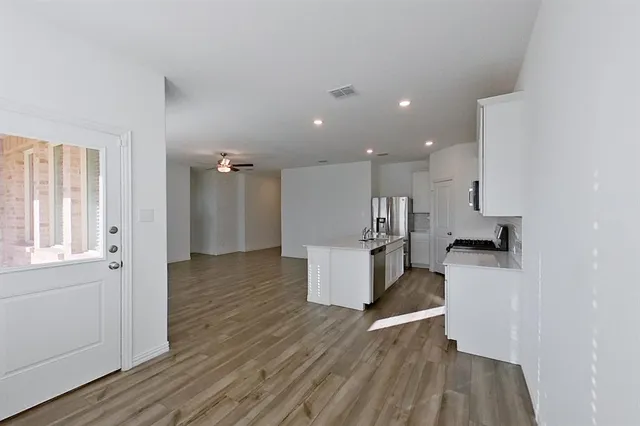 a kitchen with a refrigerator and a stove top oven