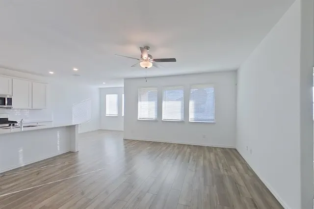 an empty room with wooden floor and windows