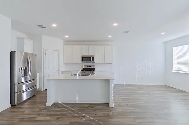 a kitchen with stainless steel appliances a refrigerator and a stove top oven