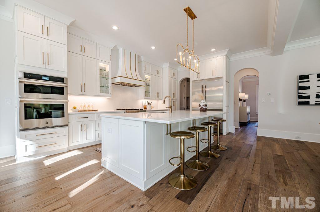 1501 Kirkby Lane Raleigh, NC 27614 - Photo 13 of 54 a kitchen with kitchen island a counter top space a stove a wooden floor and cabinets