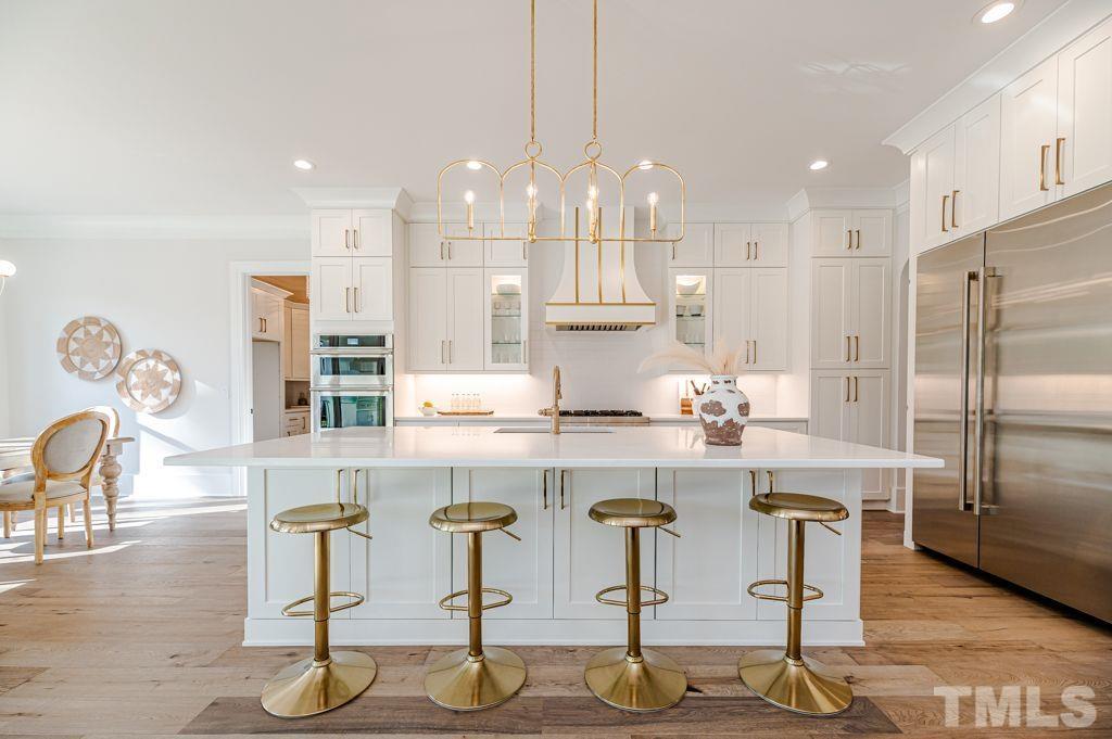 1501 Kirkby Lane Raleigh, NC 27614 - Photo 14 of 54 a kitchen with stainless steel appliances granite countertop a table chairs stove and white cabinets