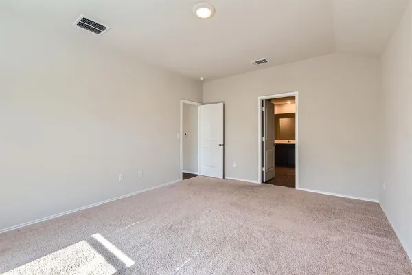 a view of an empty room with closet and a window