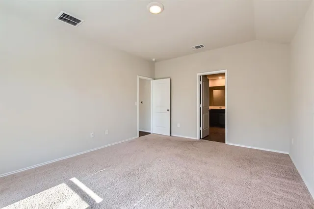 a view of an empty room with closet and a window