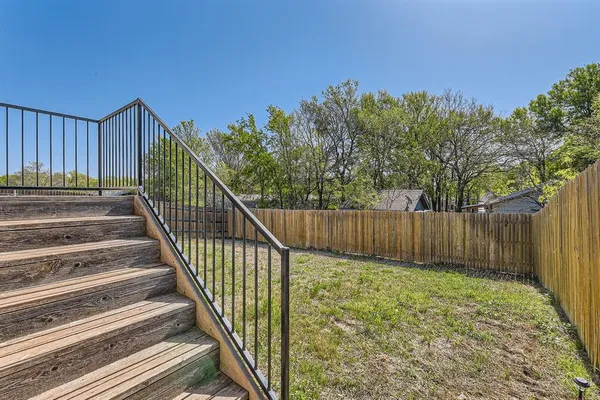 a view of backyard with wooden fence