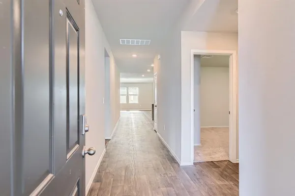 a view of a hallway with wooden floor