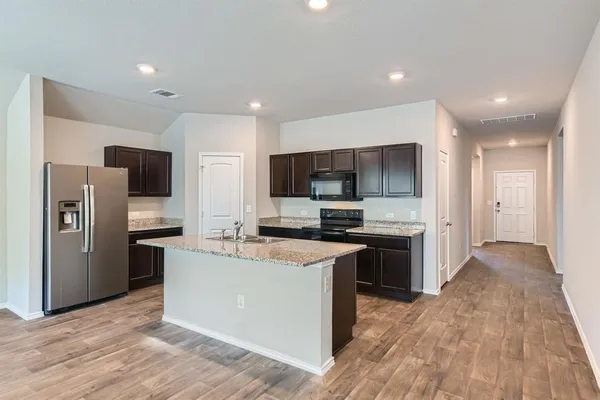 a large kitchen with stainless steel appliances kitchen island a large counter top and a stove top oven