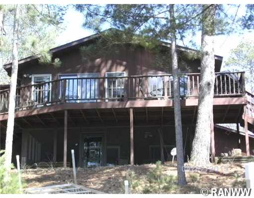 1559 Hams Road Spooner, WI 54801 - Photo 1 of 1 Exterior Front. Lake side deck runs the full length of the house , four patio doors above, screened in porch below with hot tub.