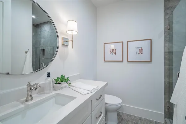 a bathroom with a granite countertop sink mirror and toilet