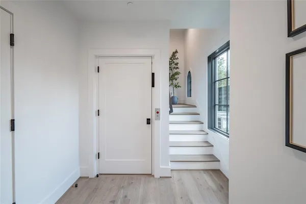a view of a hallway with wooden floor and entryway