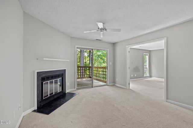 a view of an empty room with a fireplace and a window