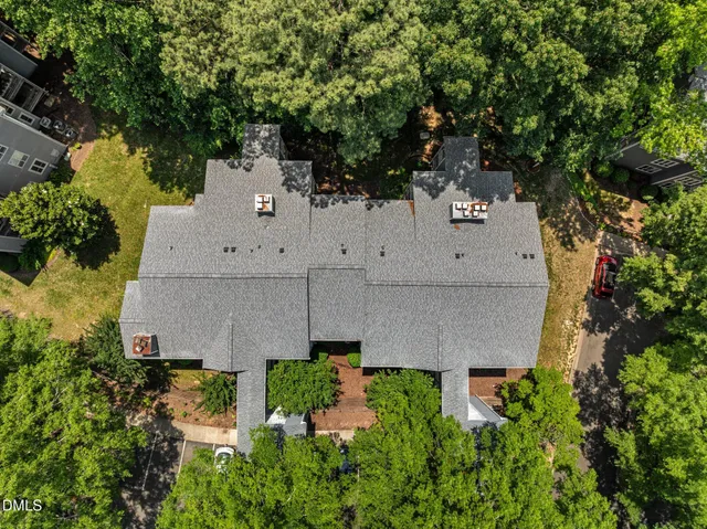 an aerial view of a house with a yard and large tree