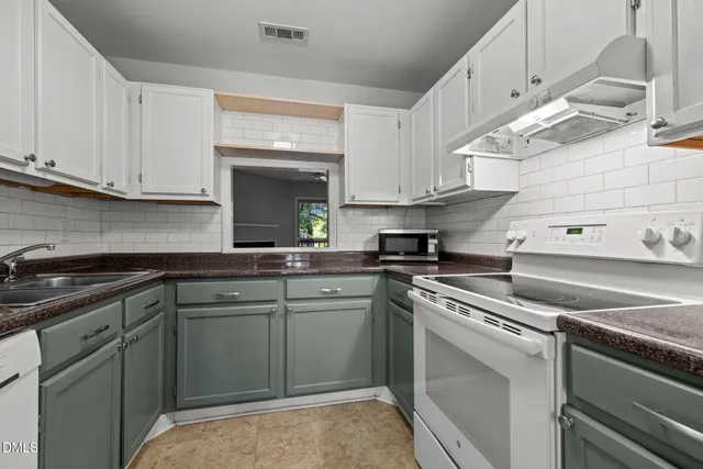 a kitchen with cabinets appliances and a sink