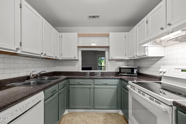 a kitchen with a sink stove top oven and cabinets