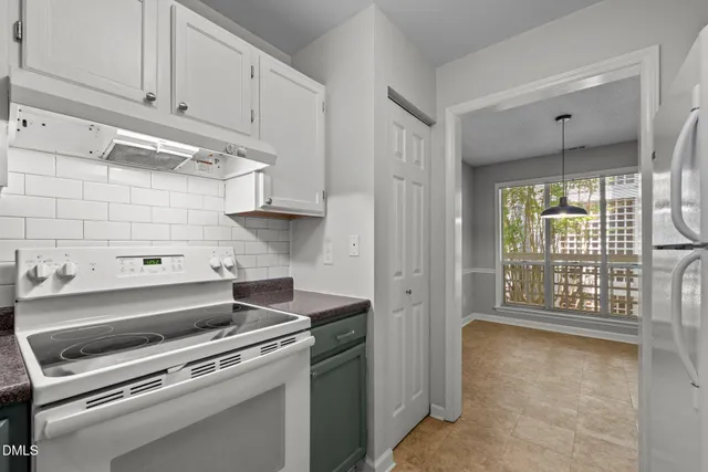 a kitchen with a stove and a white cabinet