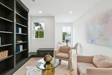 a living room with furniture and a book shelf