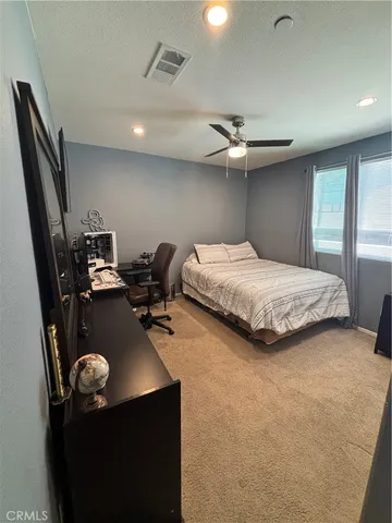 a large bedroom with a large bed and a chandelier