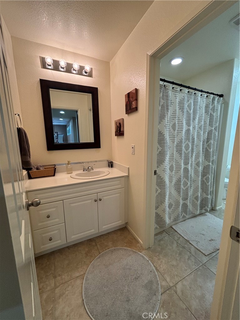 2534 Mapleleaf Terrace Palmdale, CA 93551 - Photo 38 of 48 a bathroom with a sink a mirror and a shower