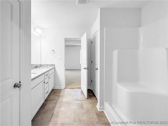 a bathroom with a granite countertop sink a mirror and a bathtub