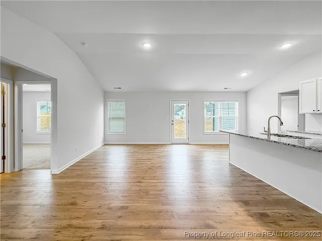 a view of empty room with wooden floor and window