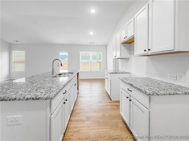 a kitchen with stainless steel appliances granite countertop a sink stove and cabinets